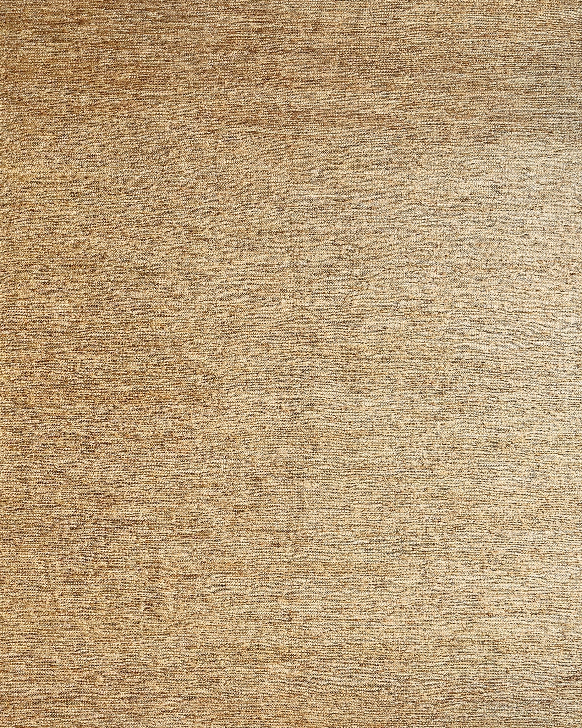 A handwoven beige jute rug with a textured surface.