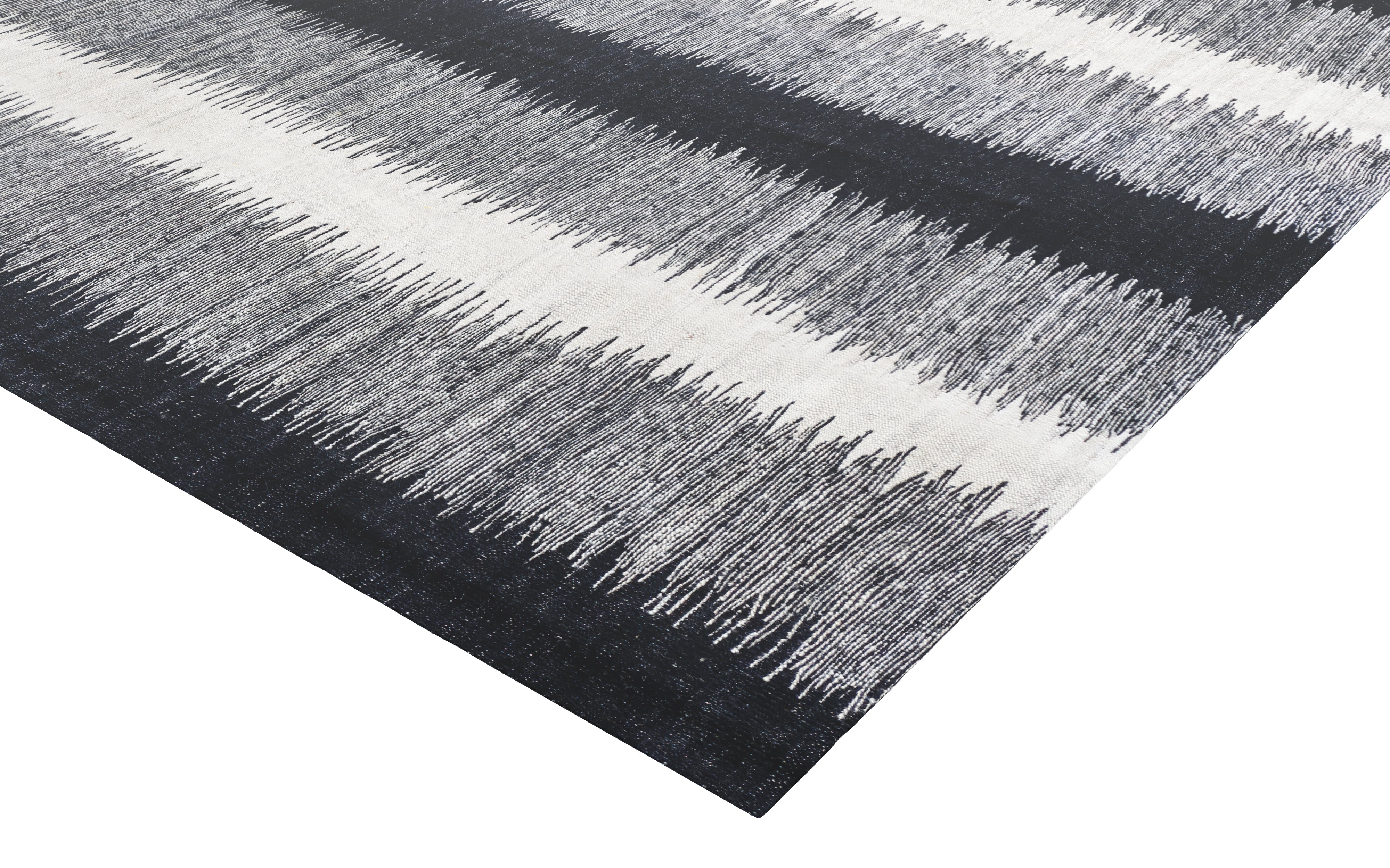 Close-up of a textured rug with black, gray, and white stripes on a white background