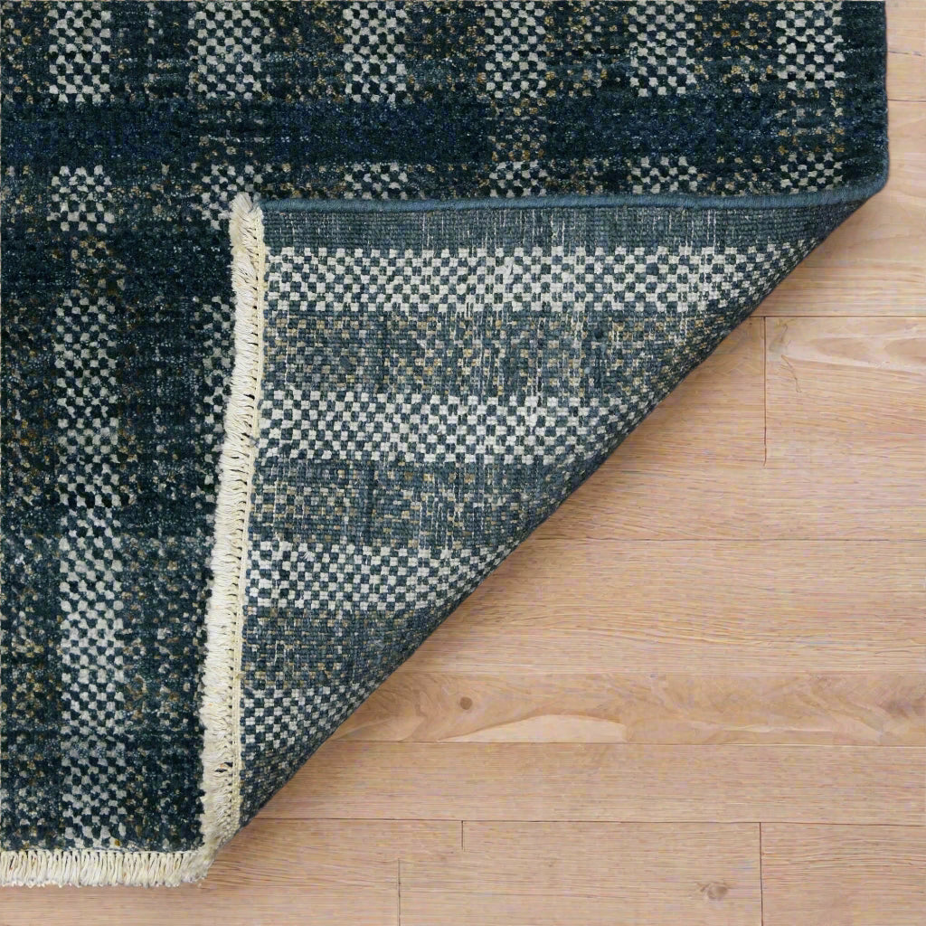dark_charcoal_checkered_rug_from_india_folded_on_white_parquet_floor