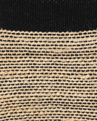 A rectangular jute rug with a striped pattern featuring black and beige colors. Bellagio black