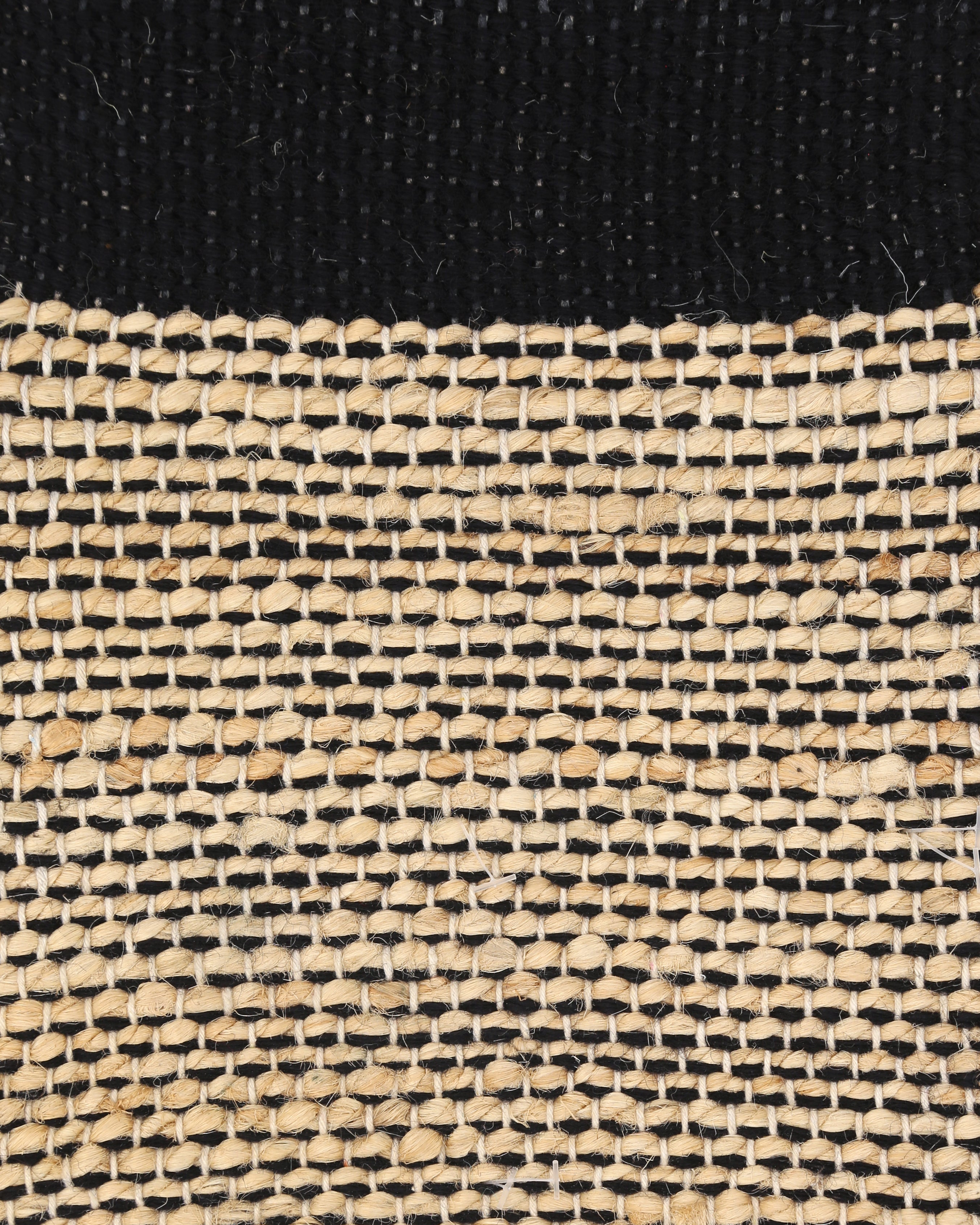 A rectangular jute rug with a striped pattern featuring black and beige colors. Bellagio black