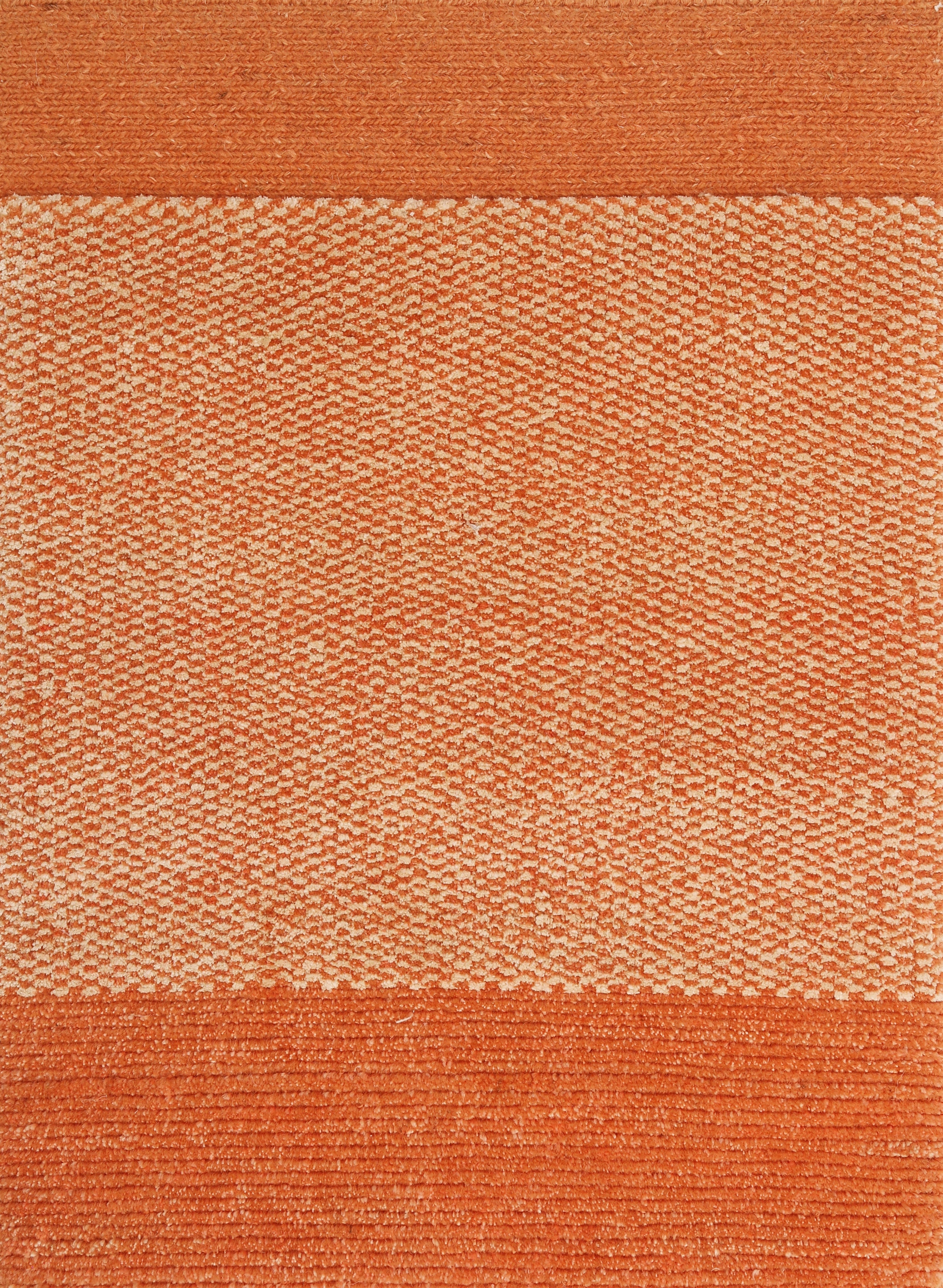 An orange textured rug with a solid color and a small pattern at the bottom.