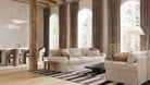 Modern living room with beige sofa, striped rug, and large windows.