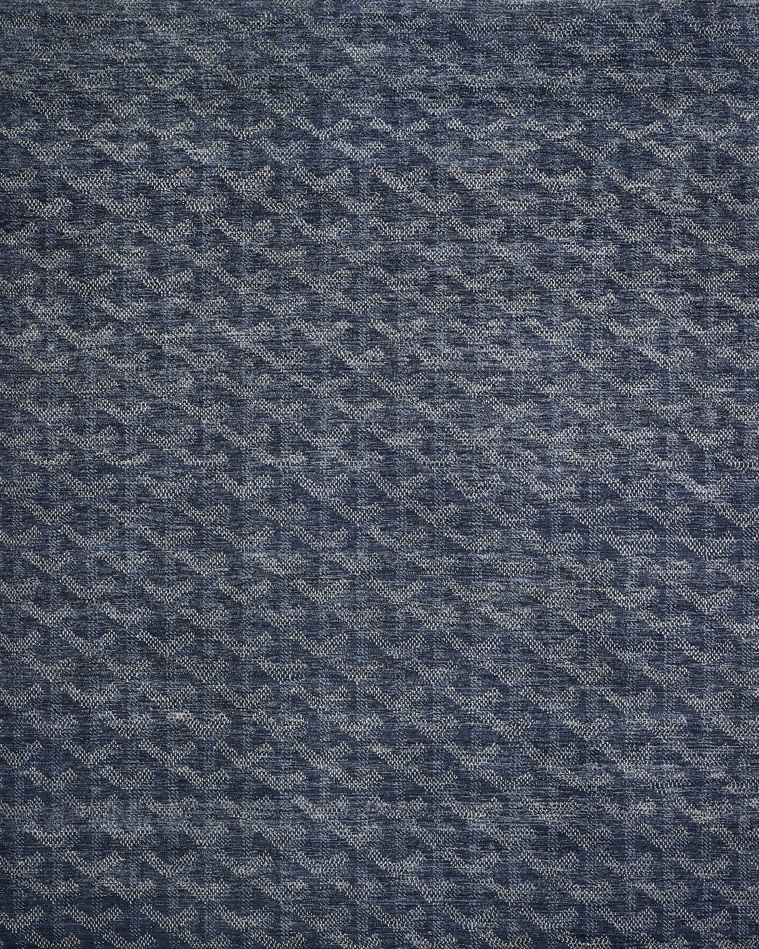 Textured blue rug with geometric pattern on a plain background