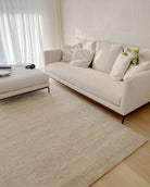 Neutral interior with Ashtari Carpets handmade rug connecting open living space in Knokke apartment